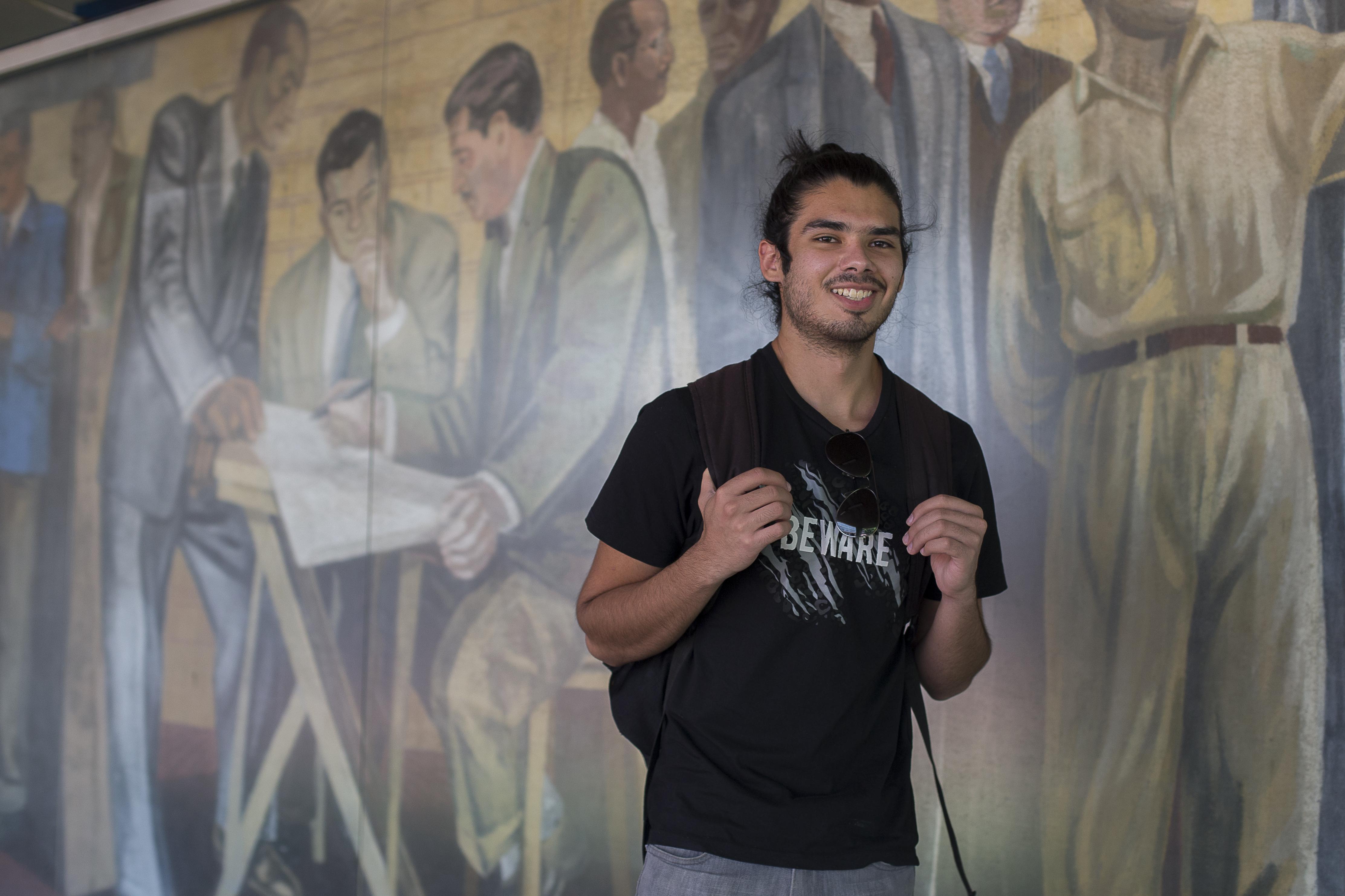 Young refugee student poses for photographs on campus